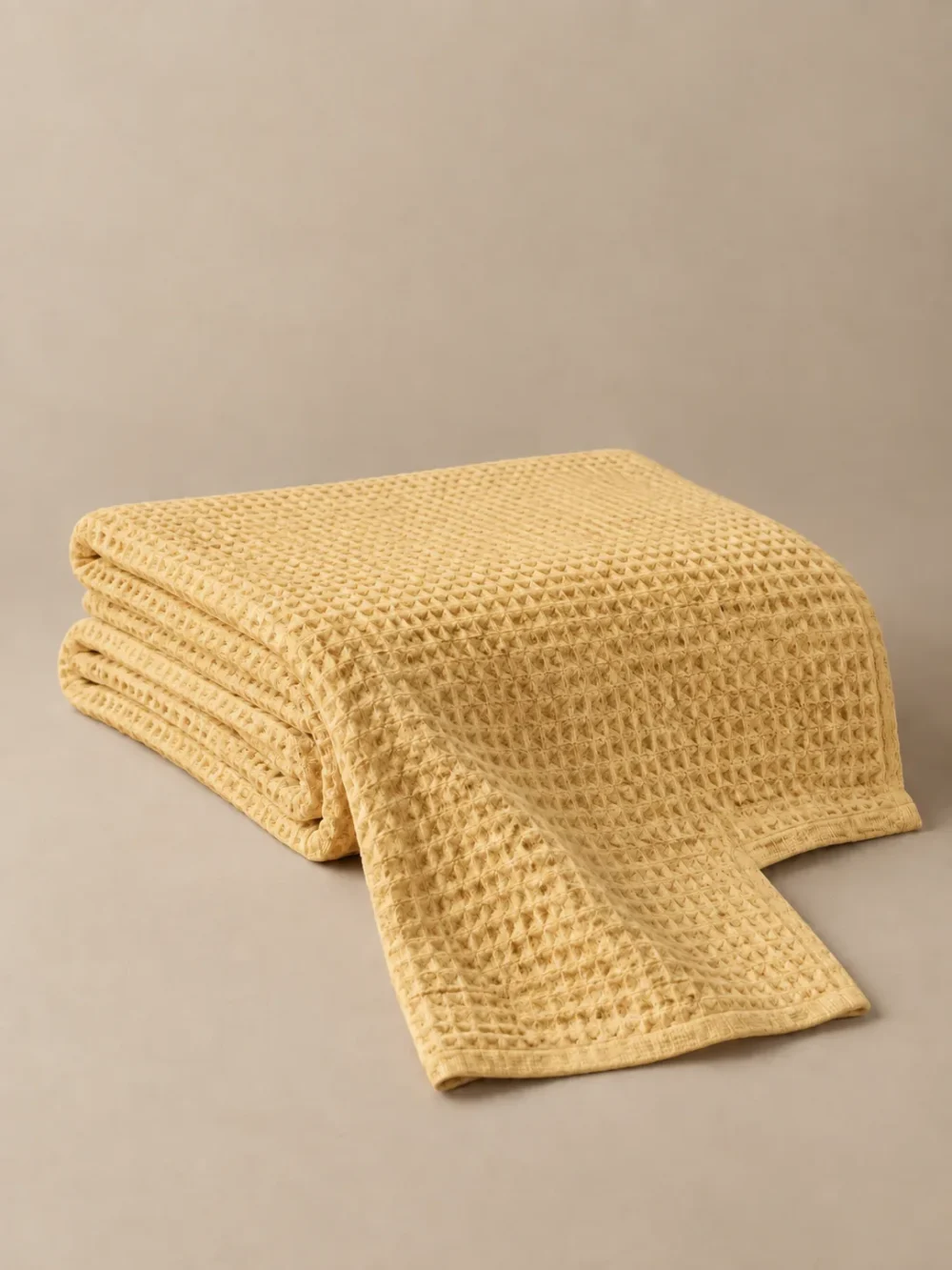 Ebb Waffle Throw in Ochre, folded, showing the edge finish