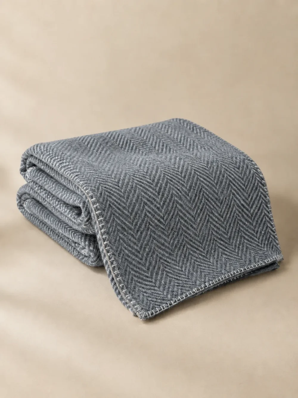 Fell Herringbone Throw in Mist, folded, showing the edge finish