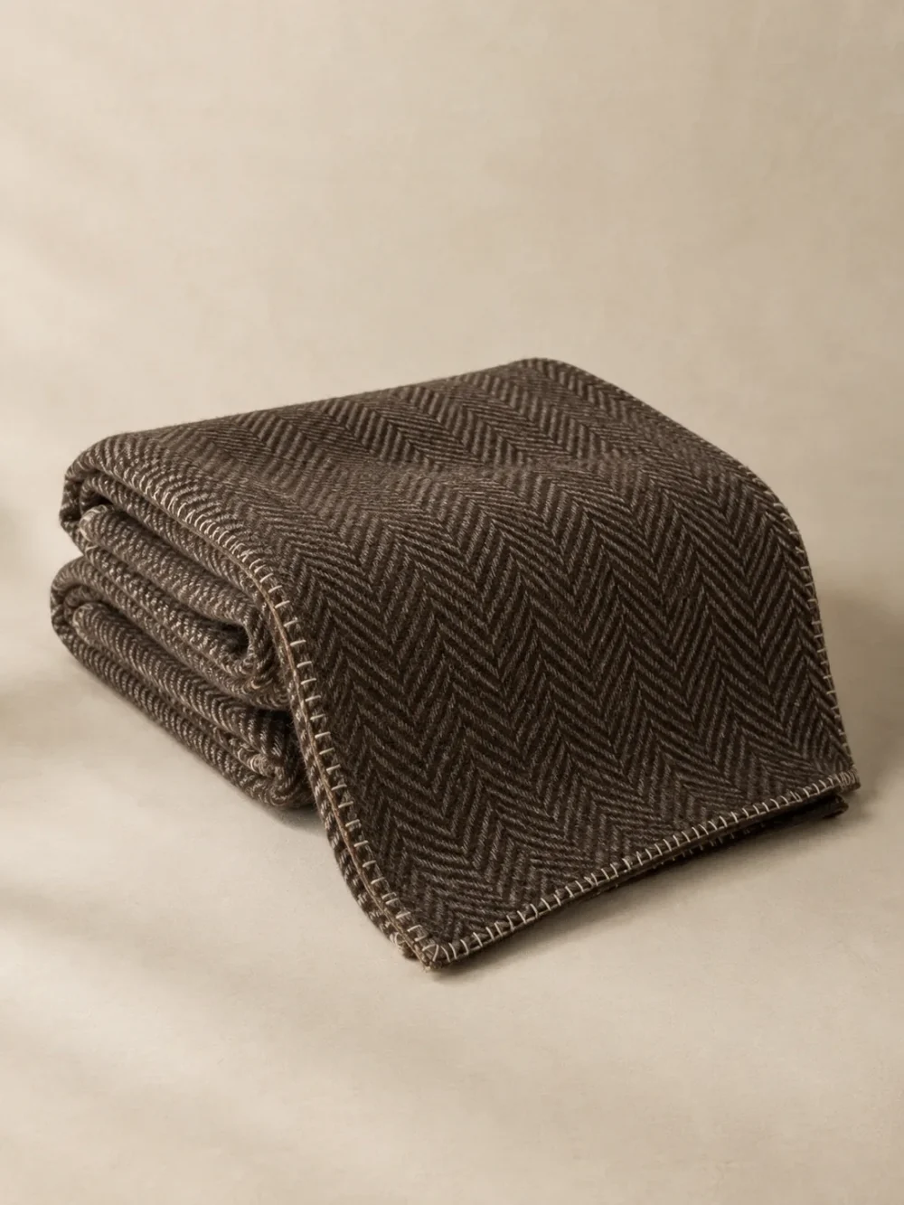 Fell Herringbone Throw in Peat, folded, showing the edge finish