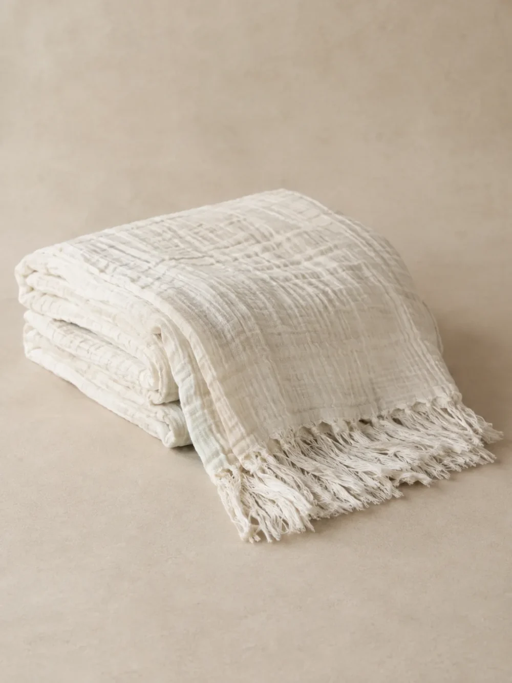 Mist Gauze Throw in Chalk, folded, showing the edge finish