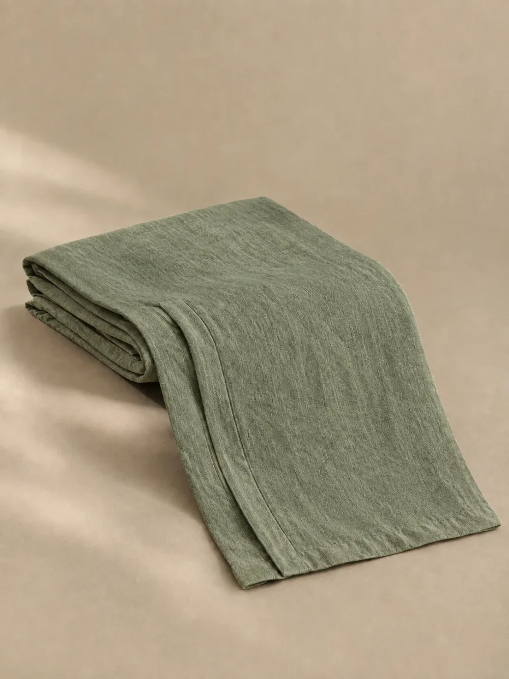 Skerry Folded Linen Runner in Moss, folded, showing the edge finish