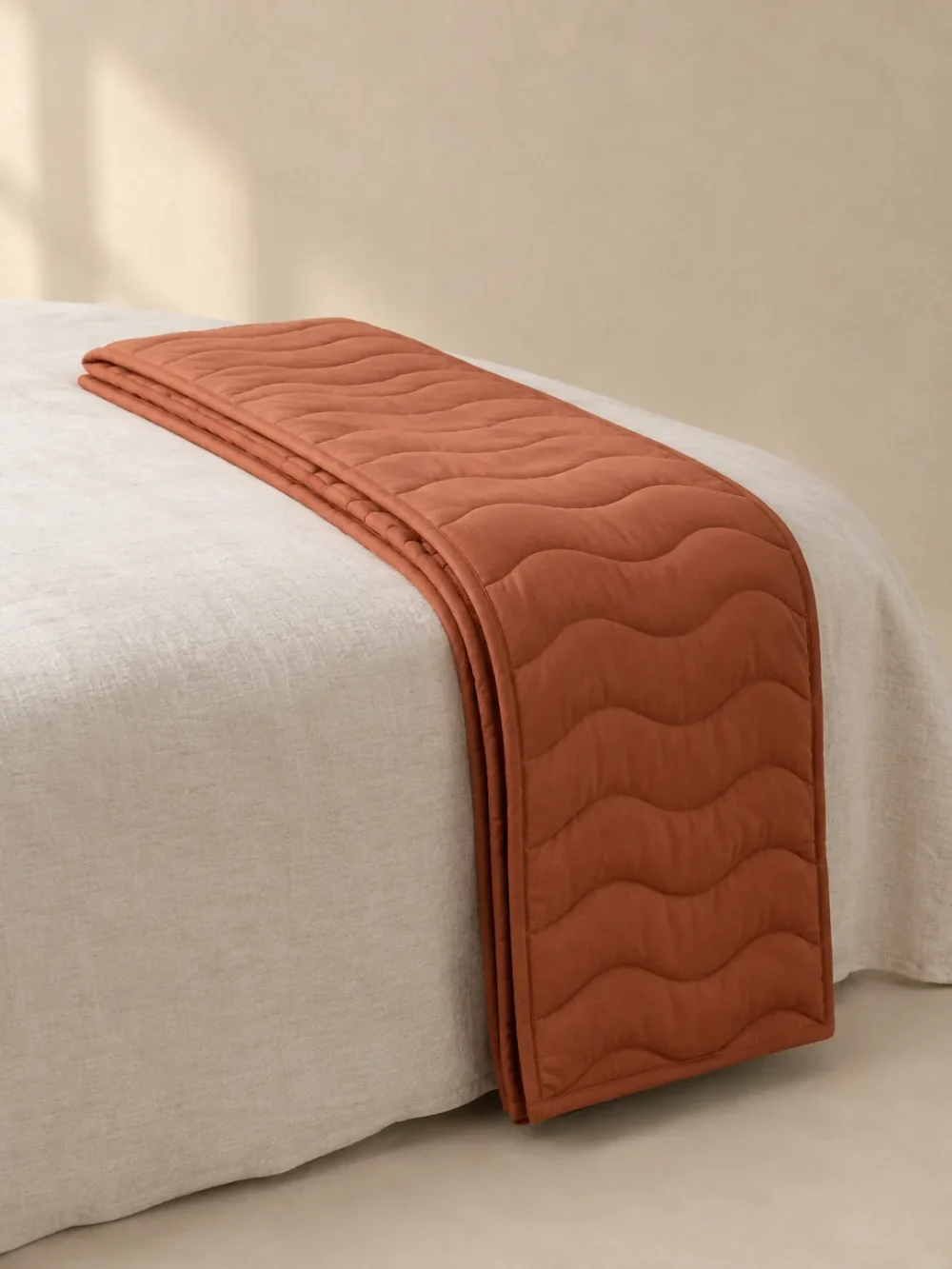 Swell Quilted Bed Runner in Clay, folded, showing the edge finish