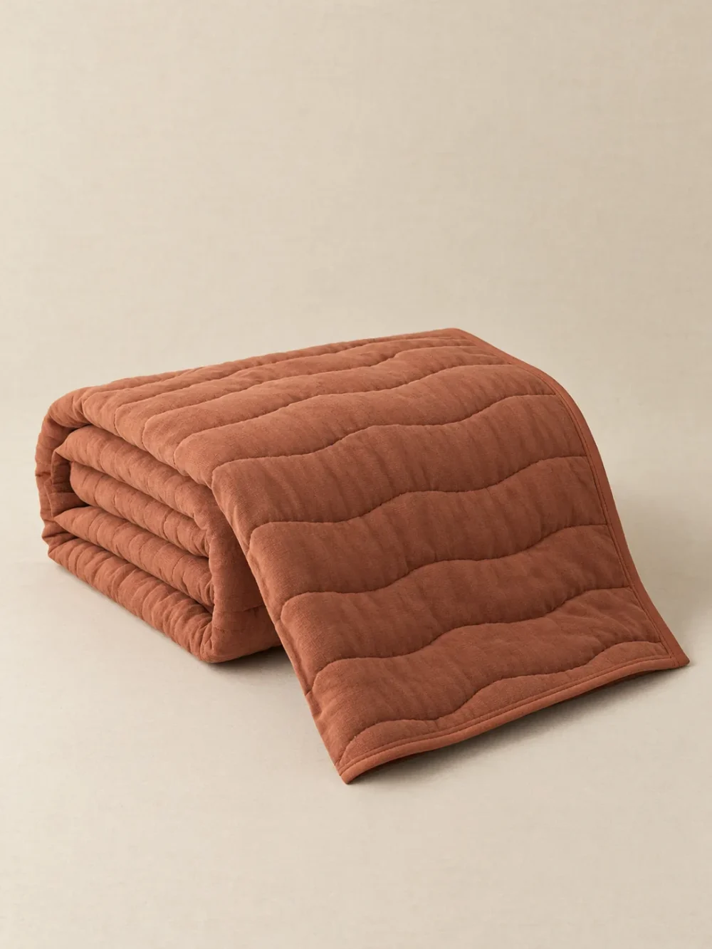 Swell Quilted Throw in Clay, folded, showing the edge finish